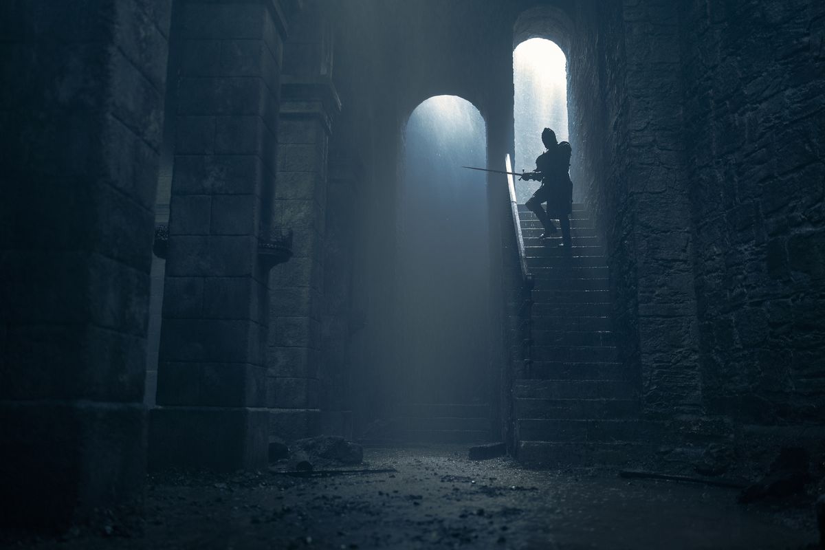 Daemon (Matt Smith) with his sword out walking down steps at Harrenhal in House of the Dragon season 2