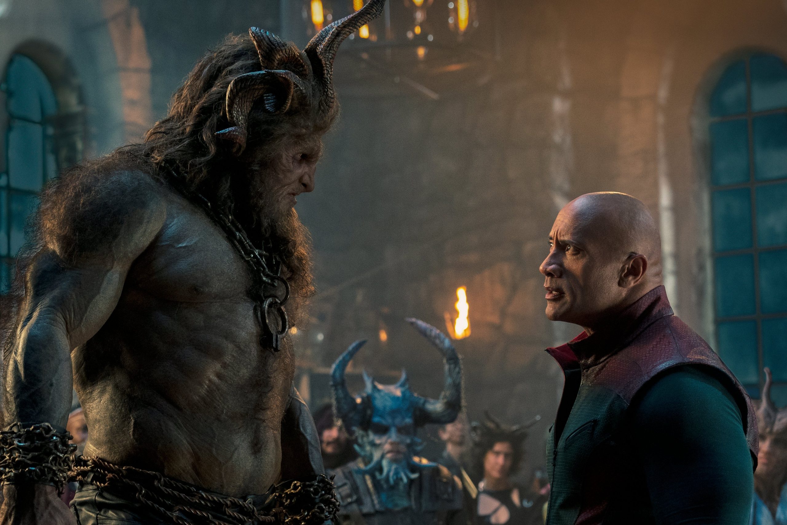 Dwayne Johnson standing opposite of a troll-like creature towering over him in Red One