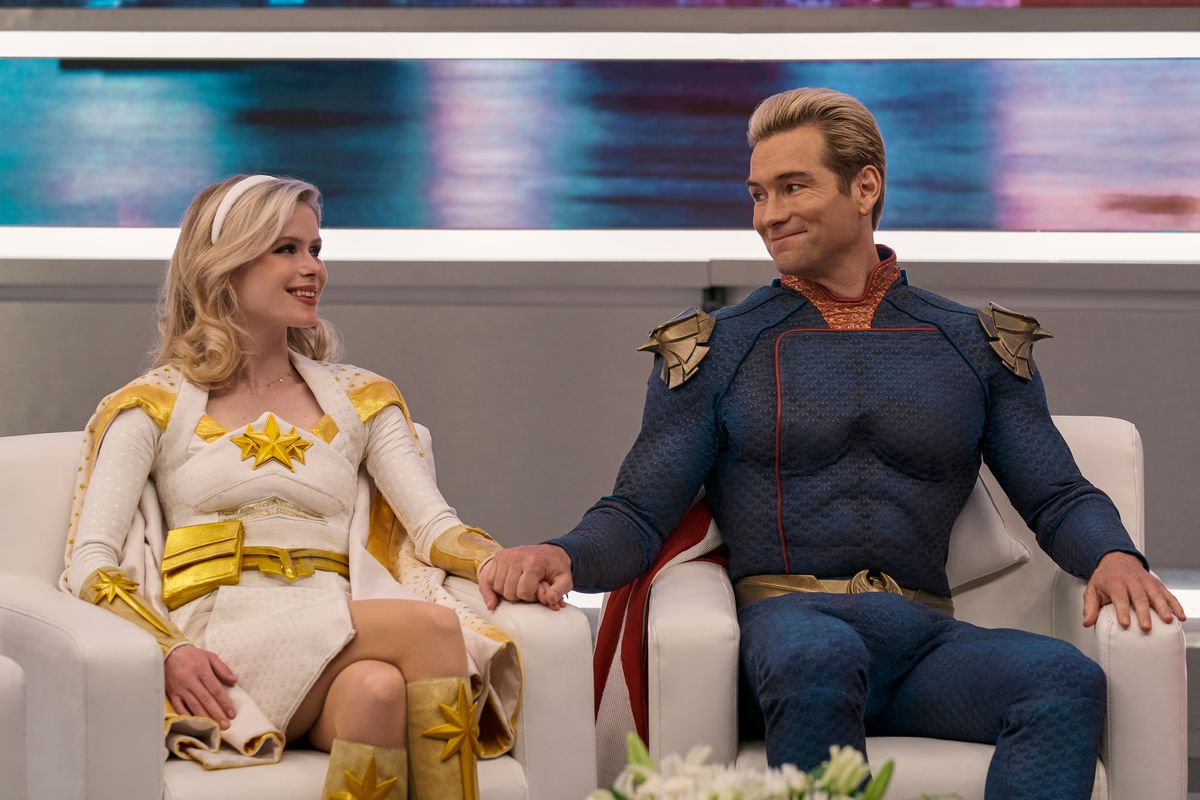 Homelander and Starlight sit on a talk show, pretending to smile at each other for the camera in The Boys season 3.