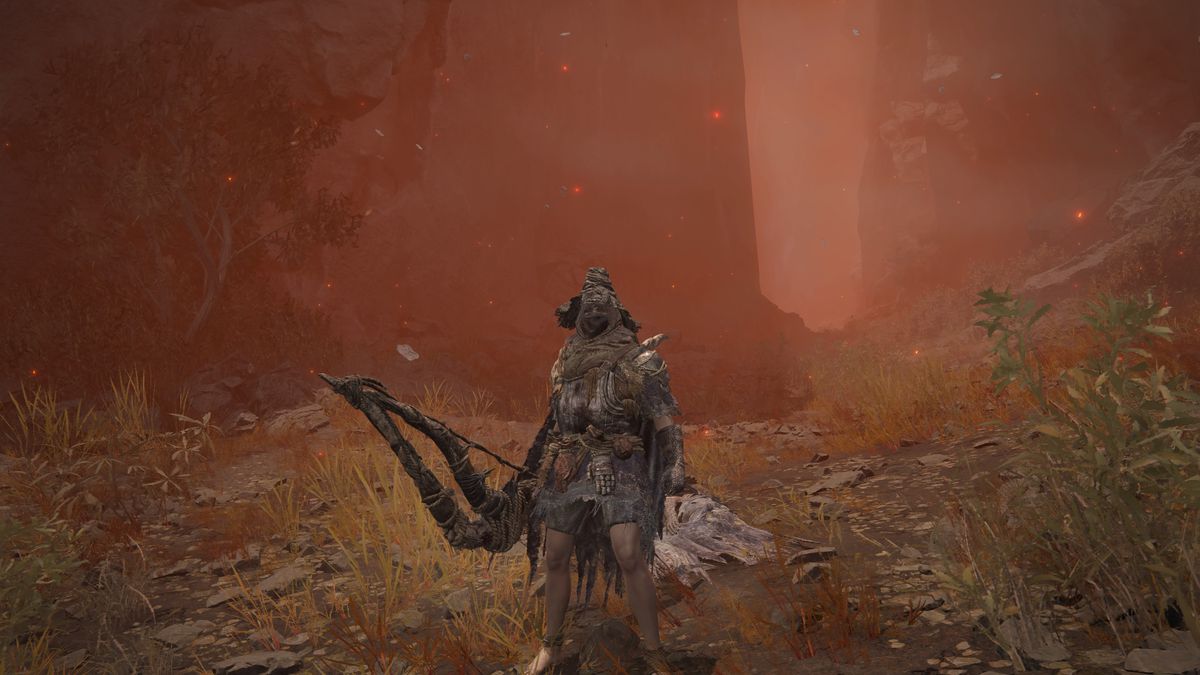 A Tarnished warrior wiedling Igon’s greatbow and armor set stands next to the corpse of Igon in a screenshot from Elden Ring: Shadow of the Erdtree